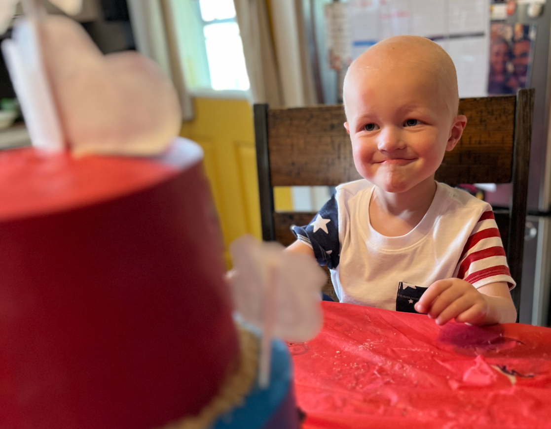 girl smiling looking at a cake