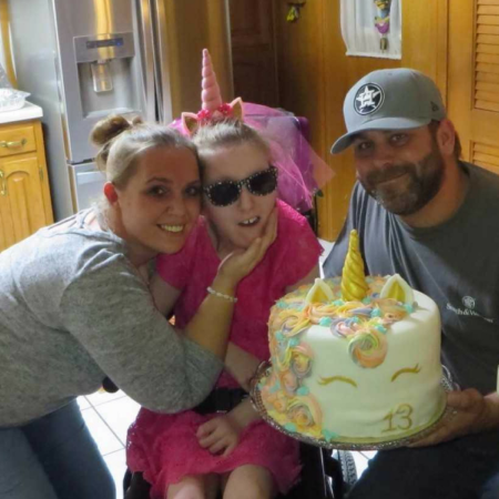 group of people smiling with a cake