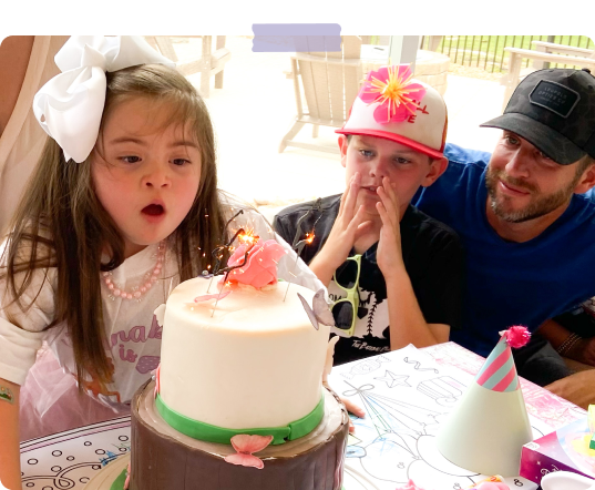 girl blowing out the candles of a cake