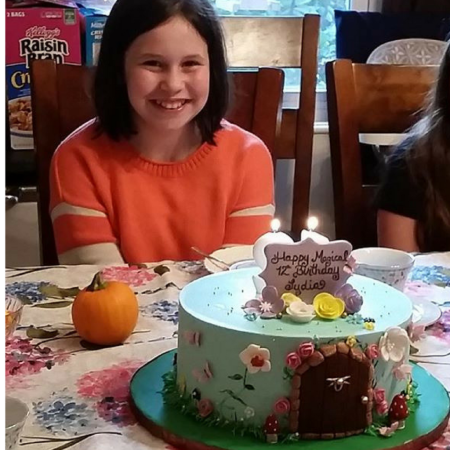 Lydia smiling with a cake