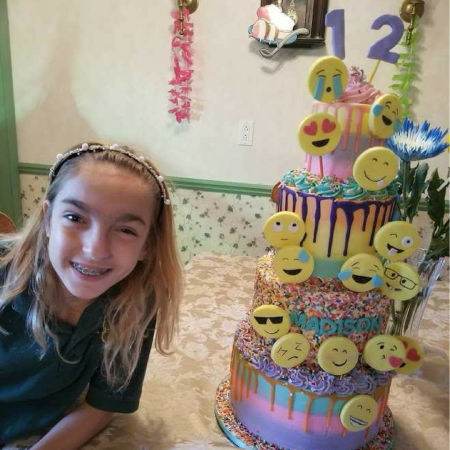 Madison smiling next to a cake