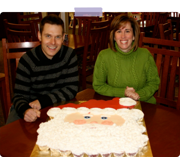 man and woman with a big santa cake