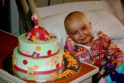 kid next to a custom cake