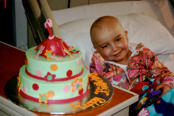 kid next to a custom cake