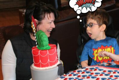 woman presenting a boy with a custom cake