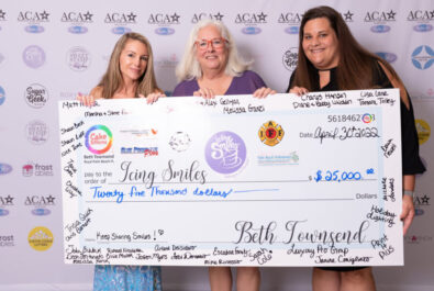 three women holding a big check