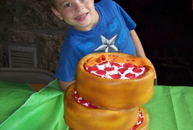 boy behind a pizza cake