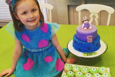 girl with monsters inc cake and cupcakes