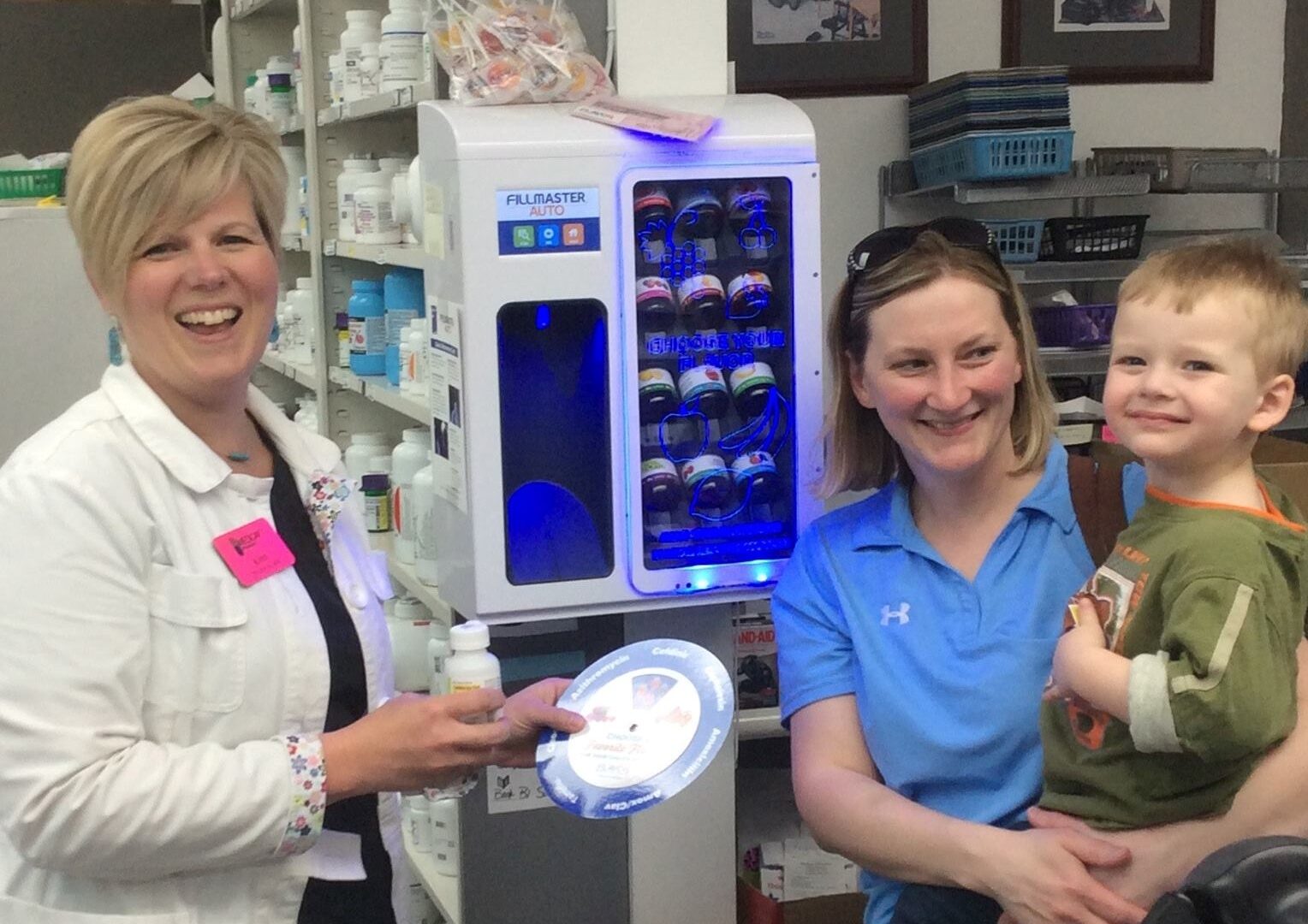 A pharmacist shows a sick child a FLAVORx wheel with options for him to choose the flavor of his medication. 
