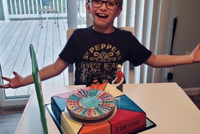 boy with a wheel of fortune cake