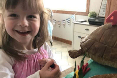 girl next to a turtle cake