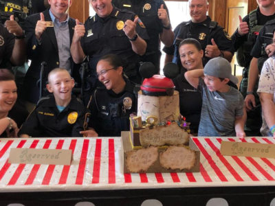 group of people crowding around a custom cake