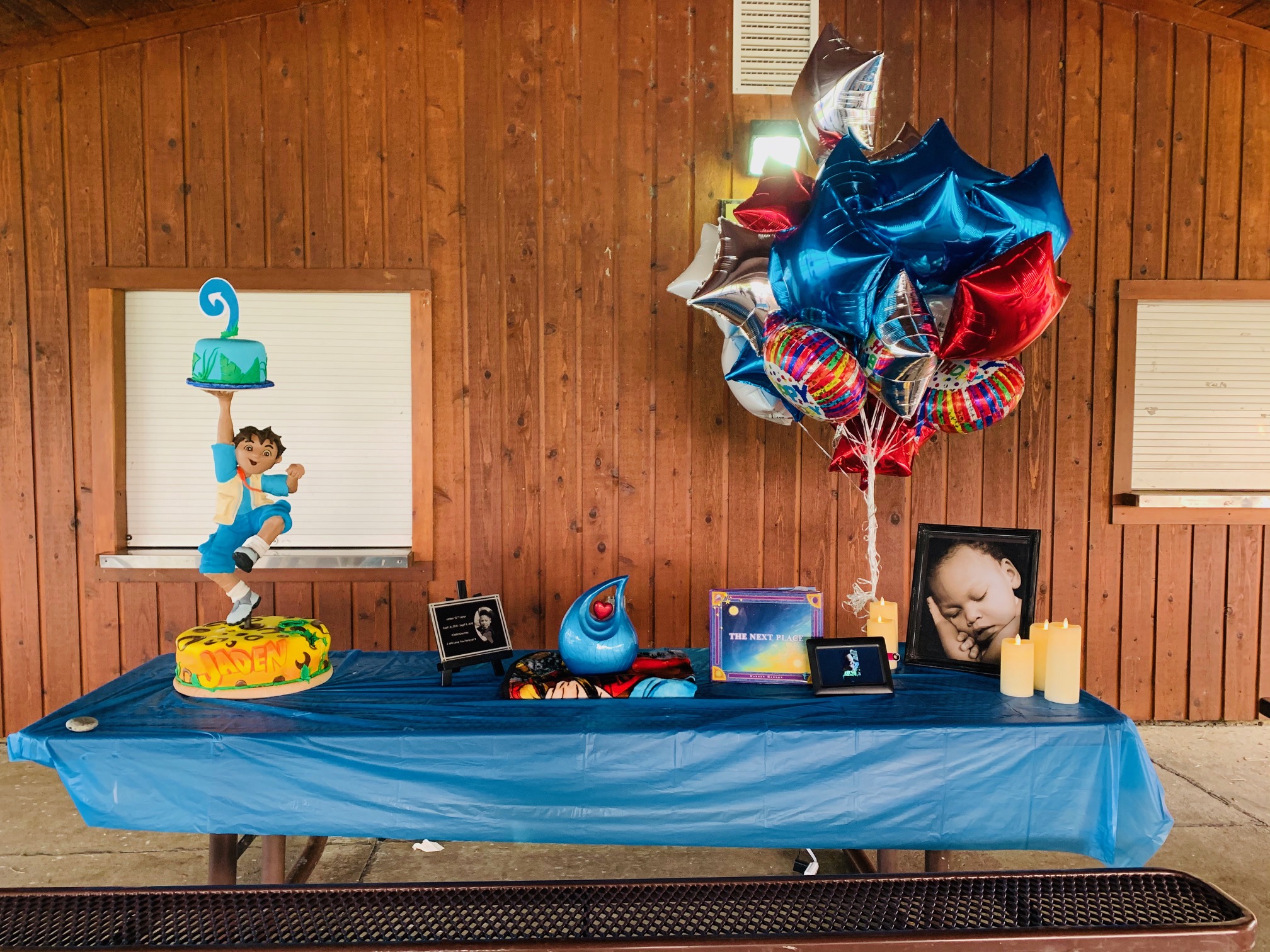 table with birthday cake, gifts, and balloons