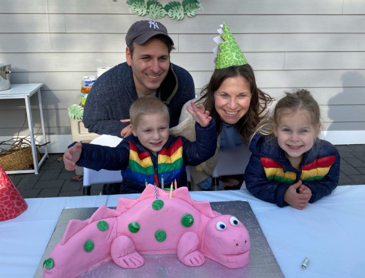 Icing Smiles family smiling with pink dino cake